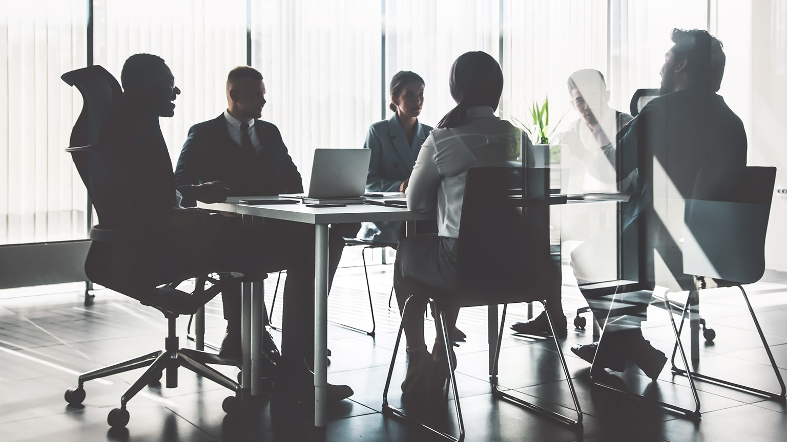 Group of professionals sitting around a boardroom table