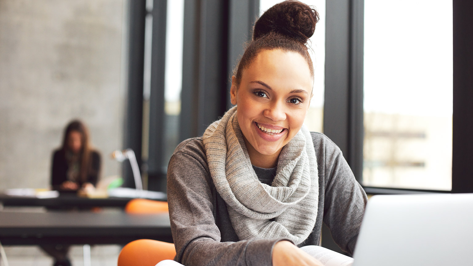 Young female student sitting and working on a laptop