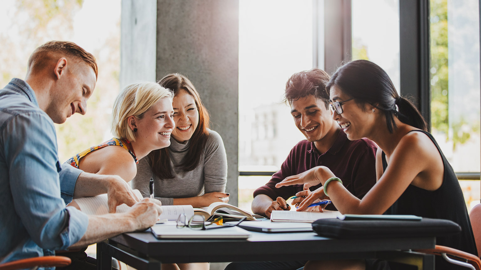 Group of students laughing around a table