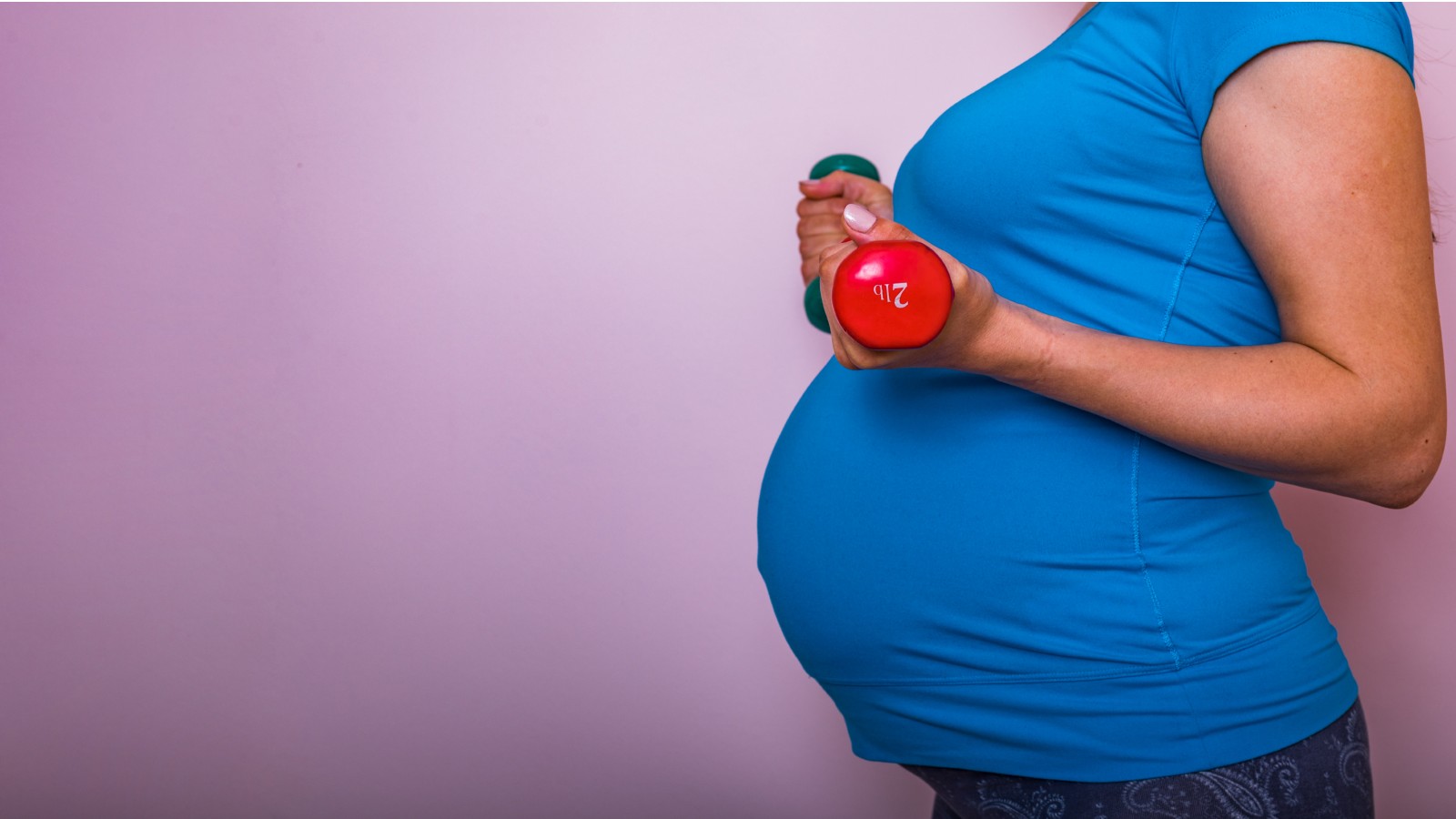 Pregnant Woman in Fitness Attire Holding Mini Dumbbells