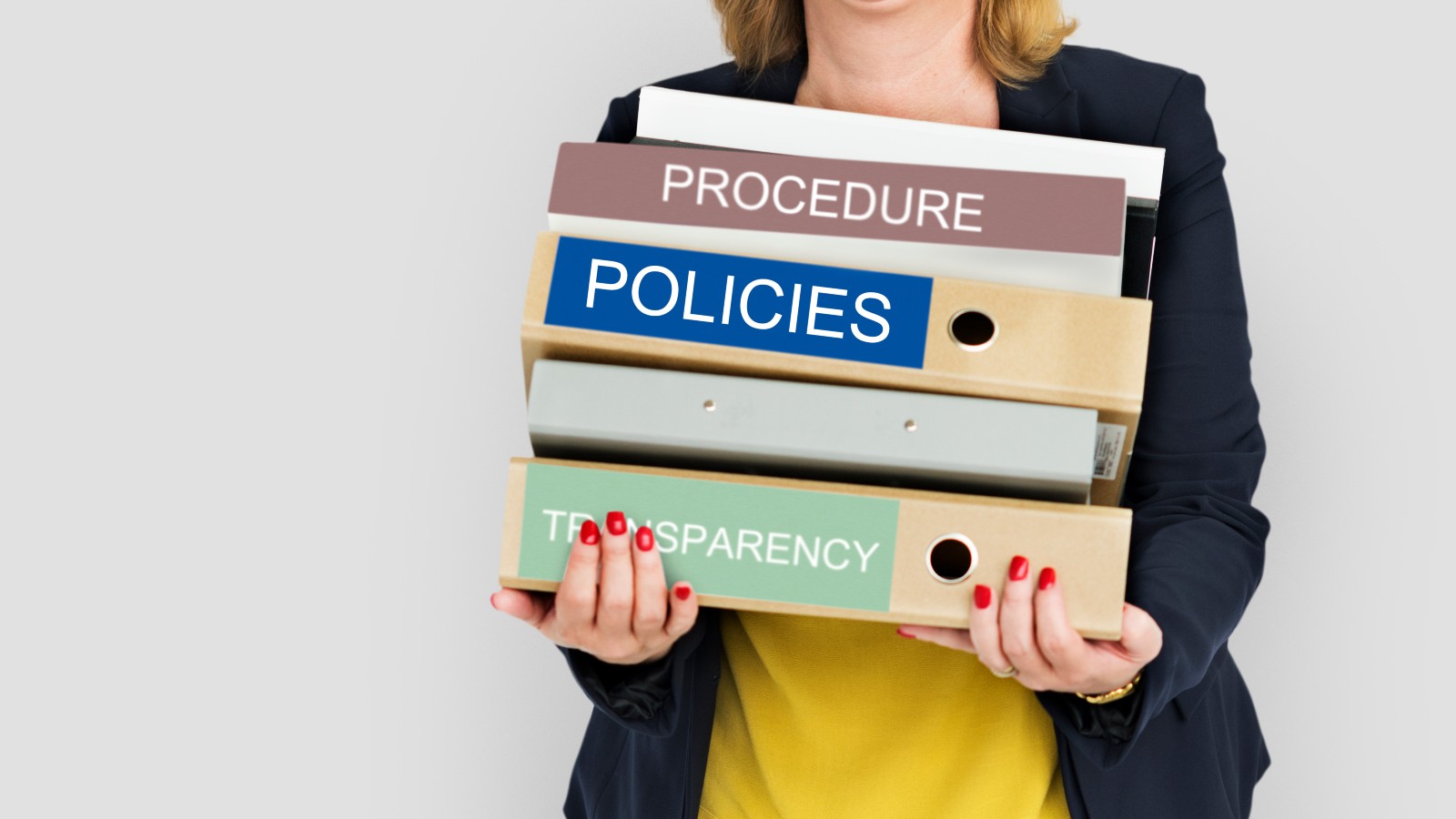 Woman holding document folders labelled policies and procedures