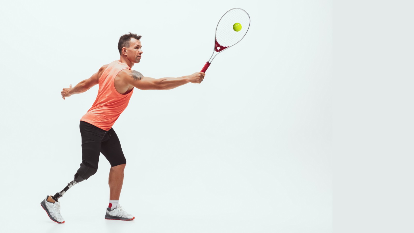 Man with an artificial leg playing tennis