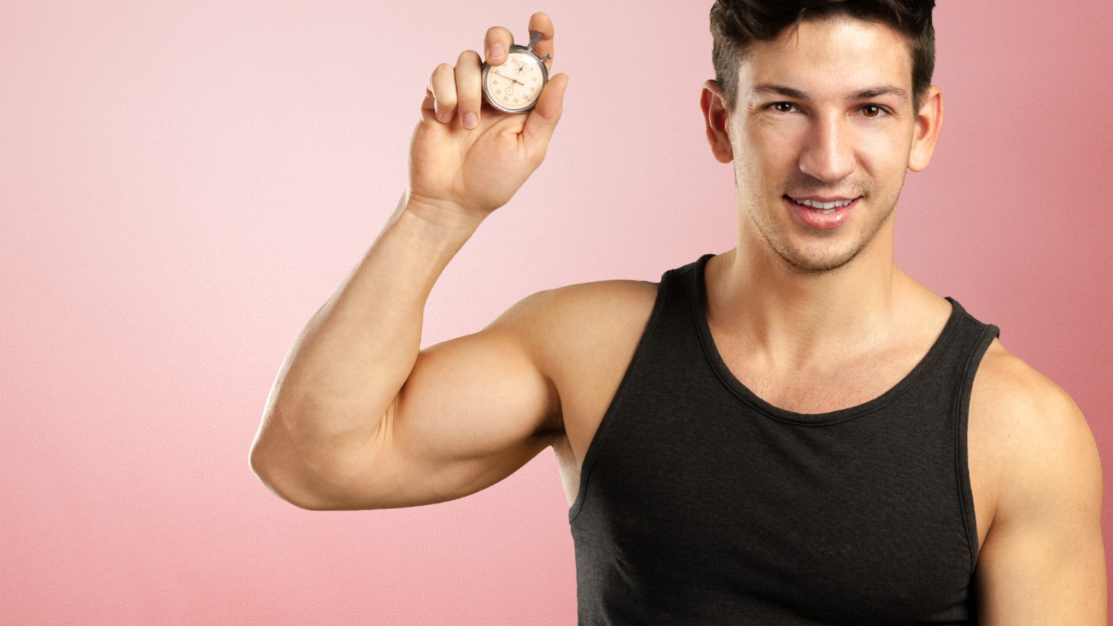 Man in fitness attire holding a stopwatch