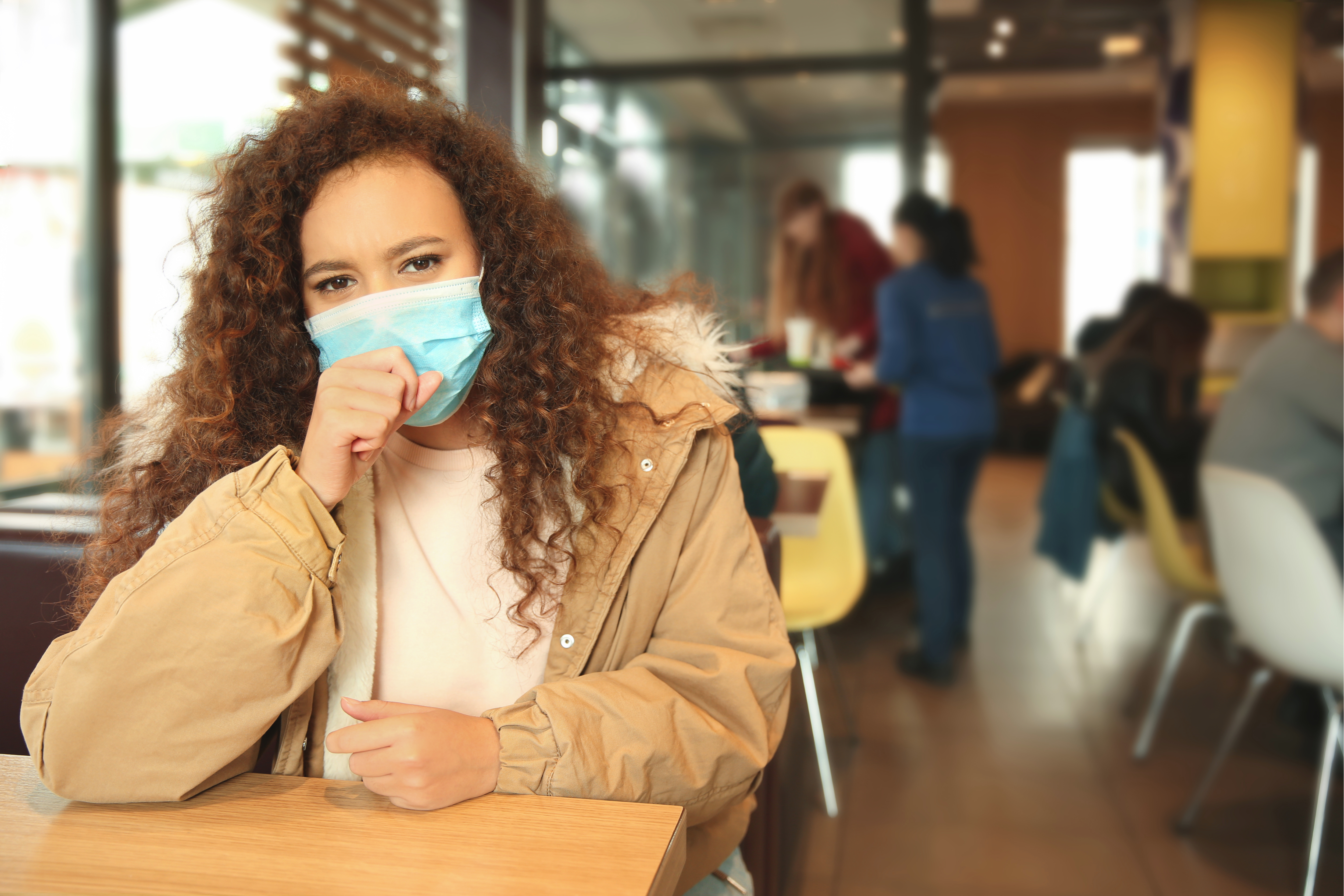 1673498392 African-American woman with disposable mask in cafe. Virus protection