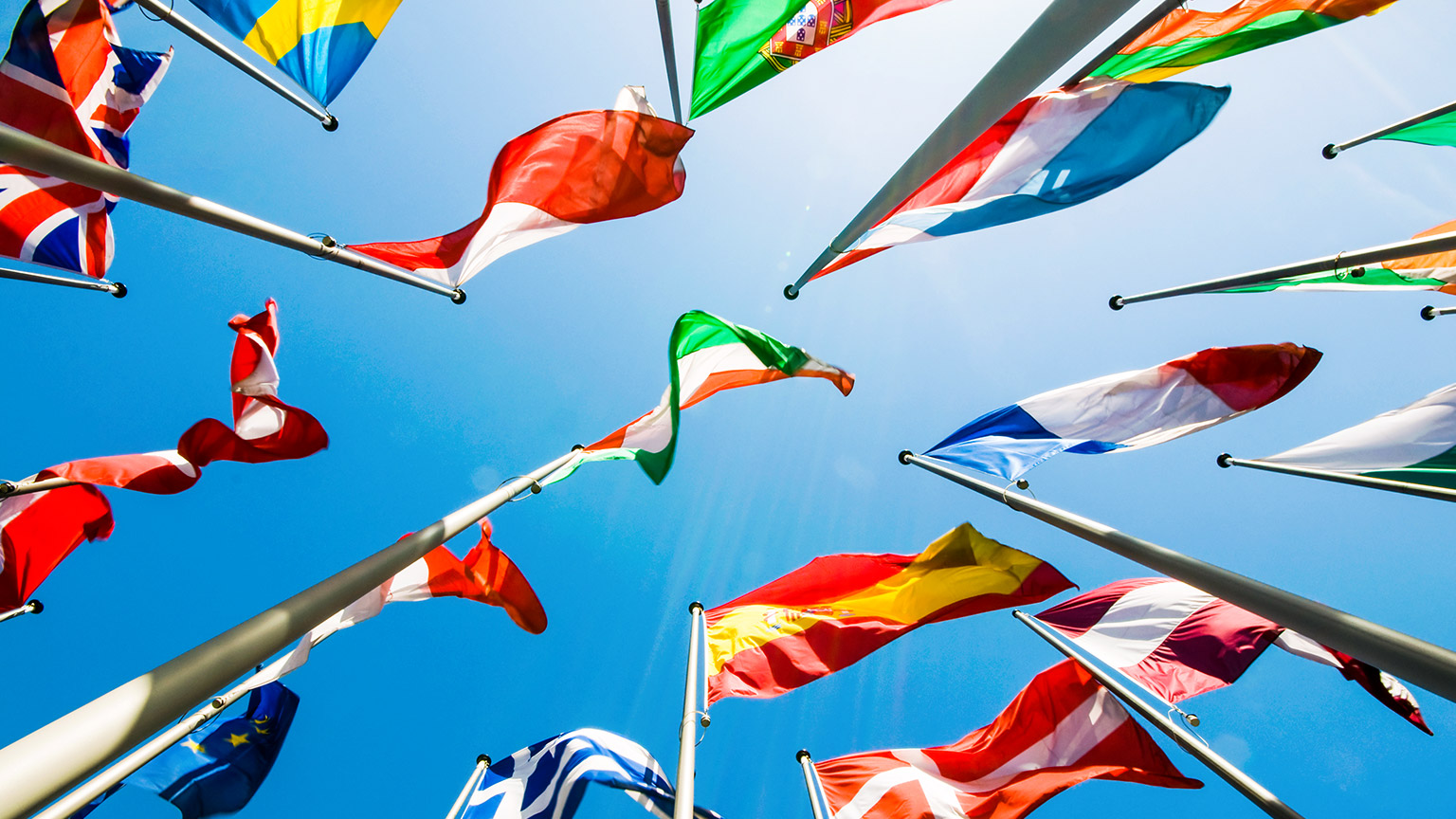 Collection of flags against a blue sky