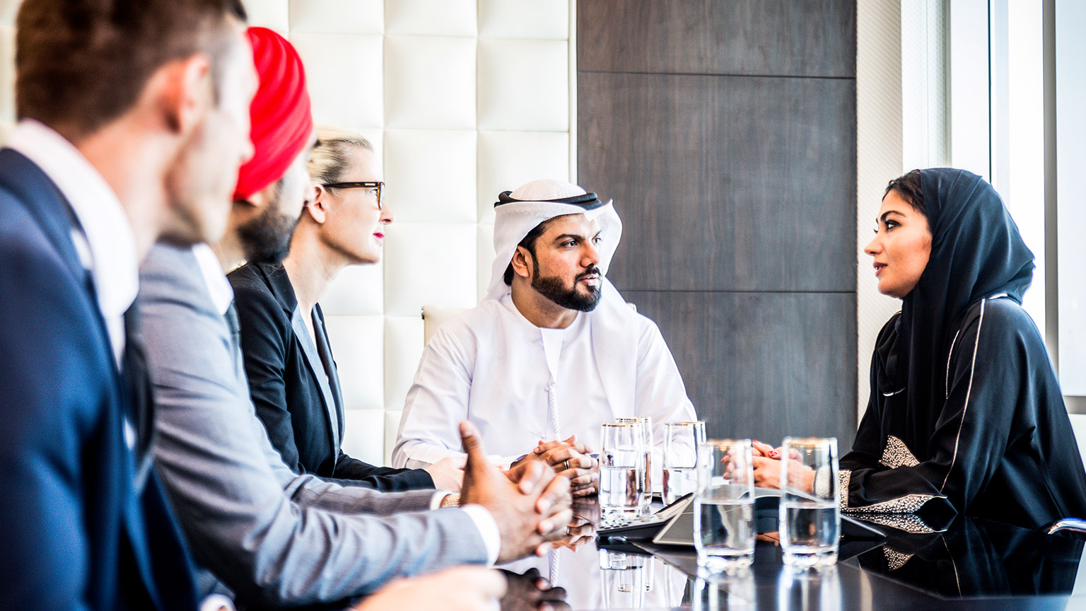 A group of multiracial professionals sitting around a table discussing business