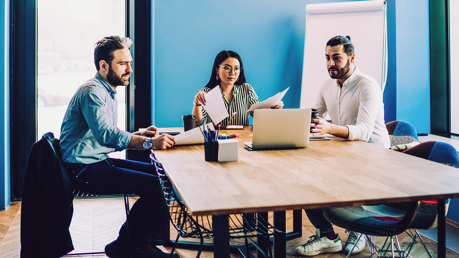 3 marketing professionals discussing financial details at a table