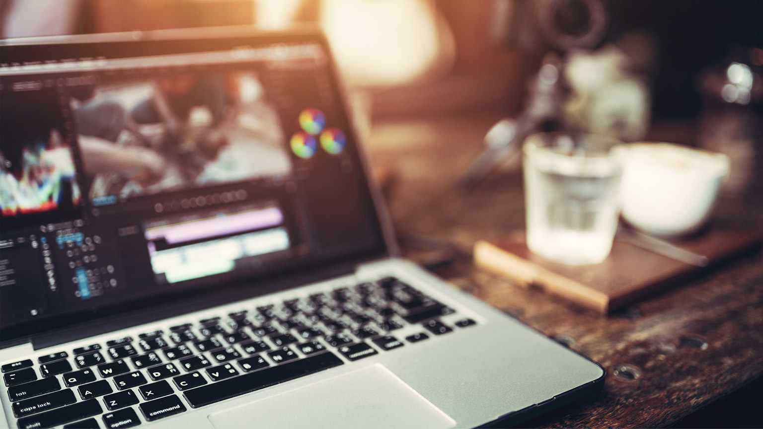 Laptop on desk with video editing software open