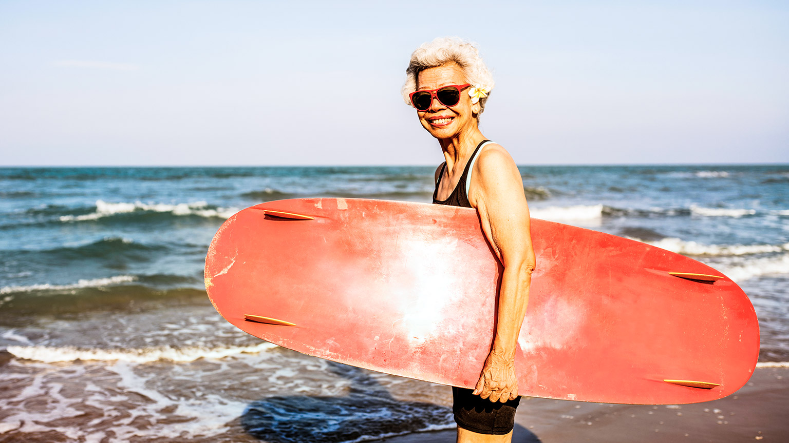 Smiling elderly female surfer