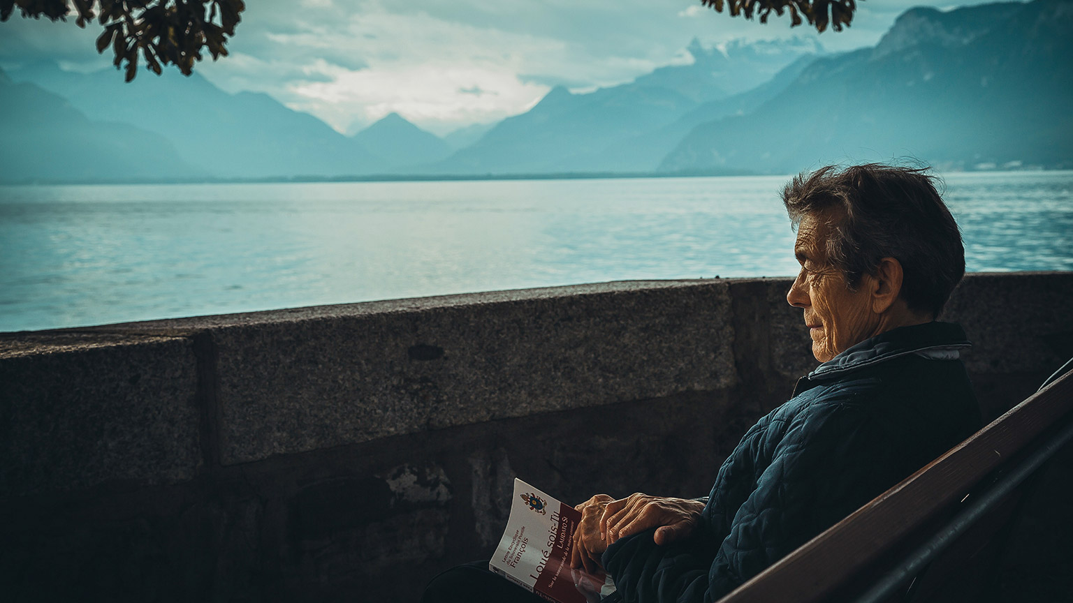 Old man reading near a lake