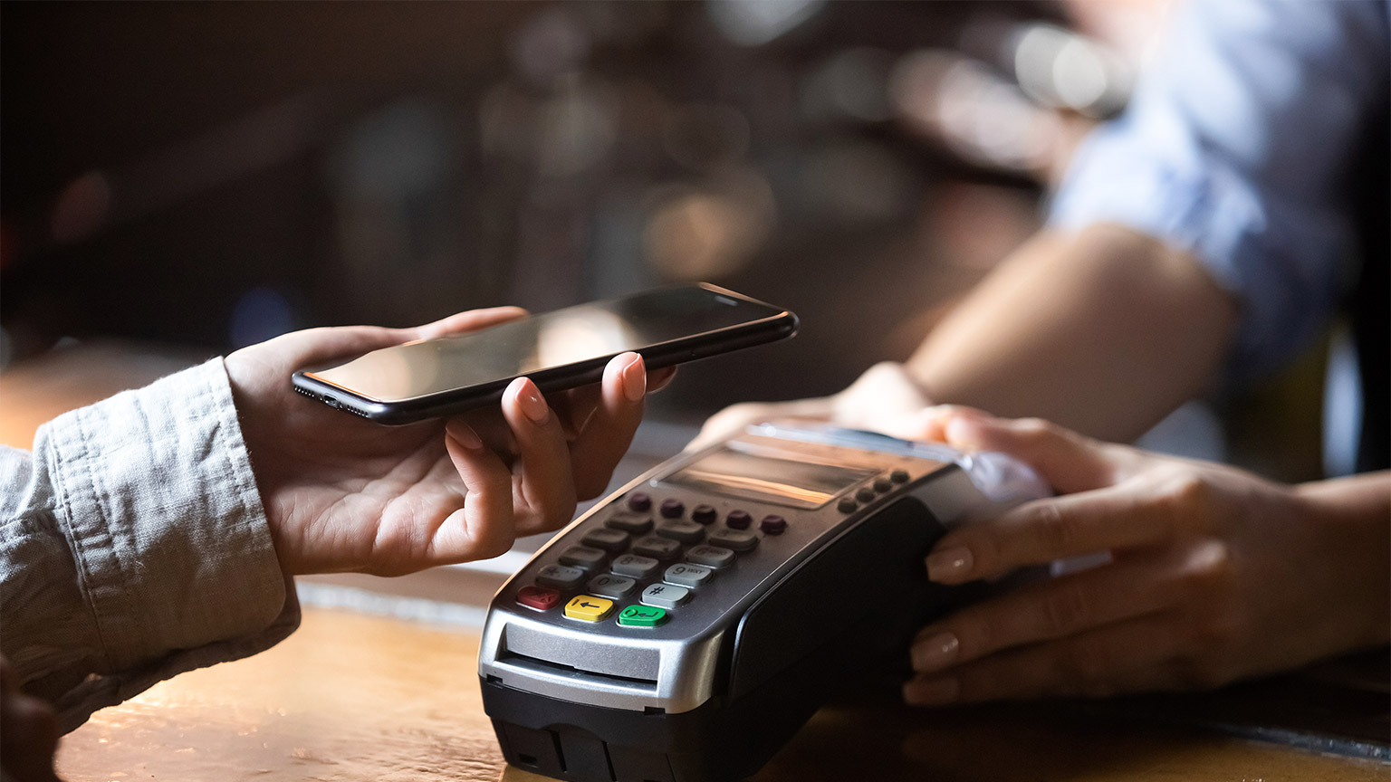 A woman making an EFTPOS payment with her smart phone