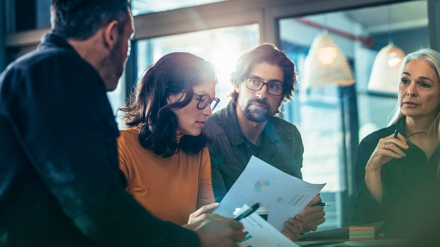 Group of business people standing around a table discussing a project