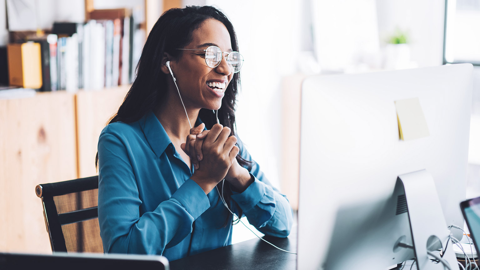 Female business person sitting at desk holding teleconference with client