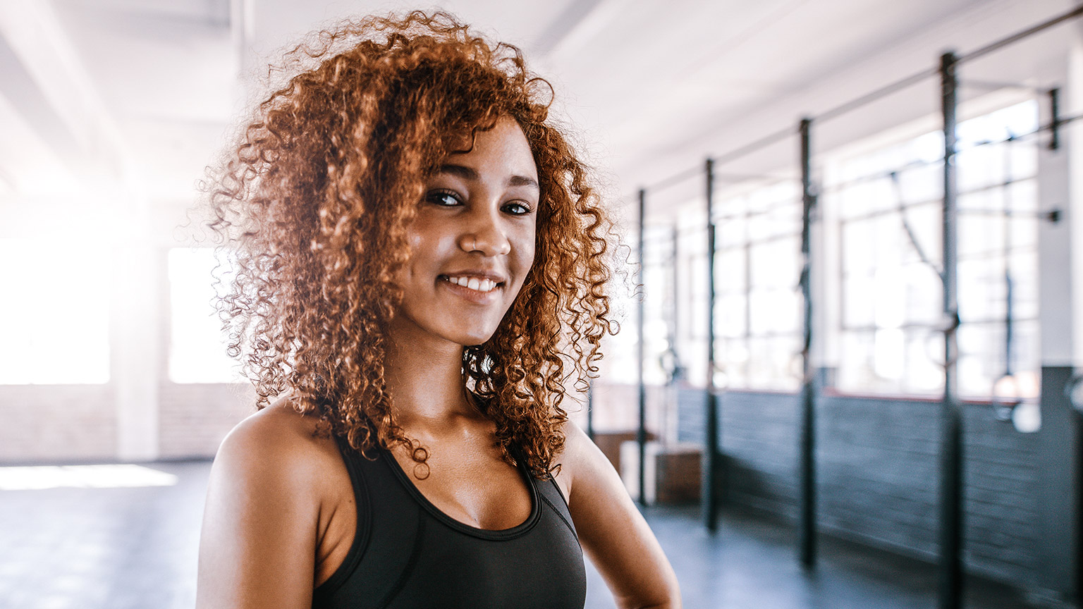 Closeup shot of fit, smiling young female in a gym