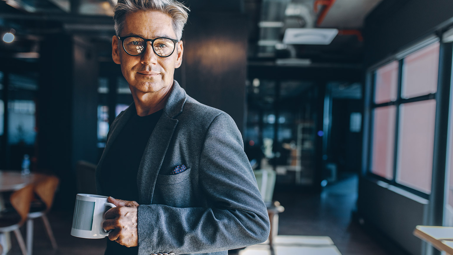 Mature male business professional standing in modern office