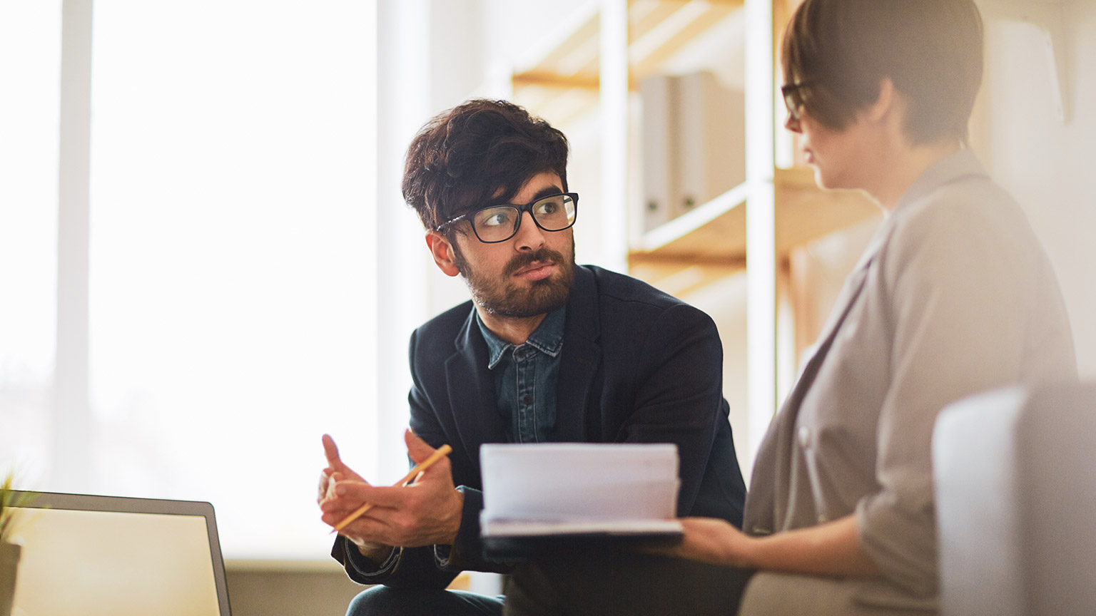 Coworkers discussing work in a relaxed office environment