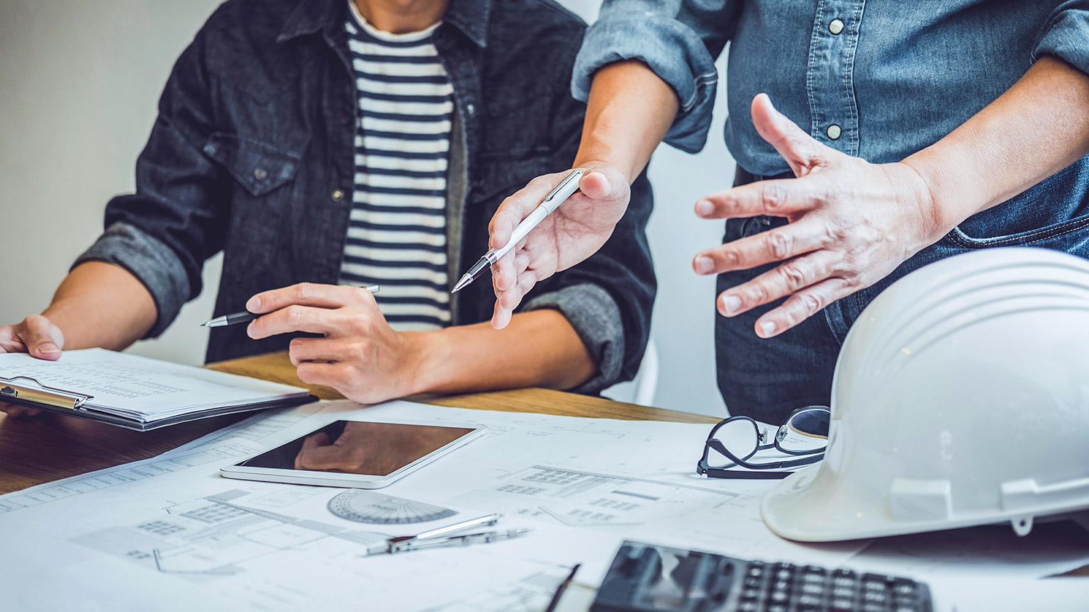 Two coworkers discussing a building contract in an office