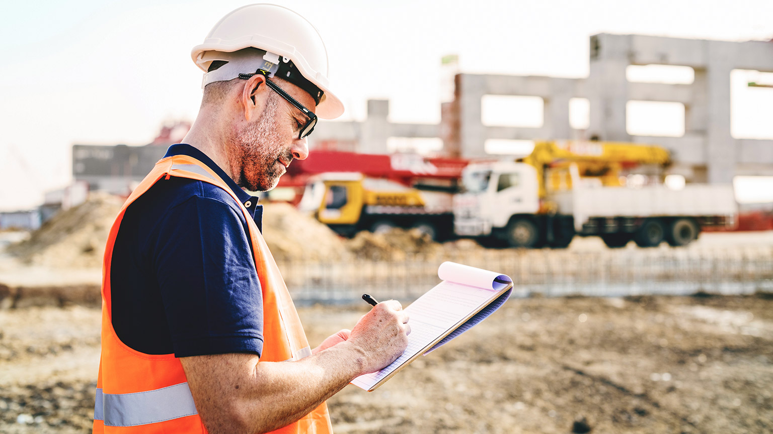 A site supervisor reviewing paperwork at a major construction