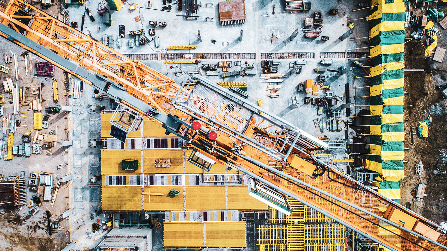 Top down view of construction site with crane and scattered building supplies