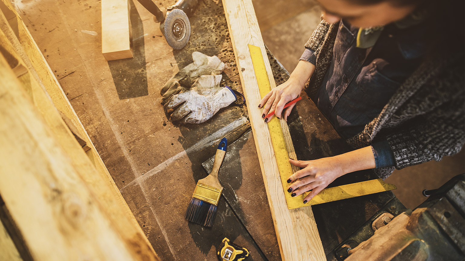 Carpenter using a steel ruler to measure lengths of wood