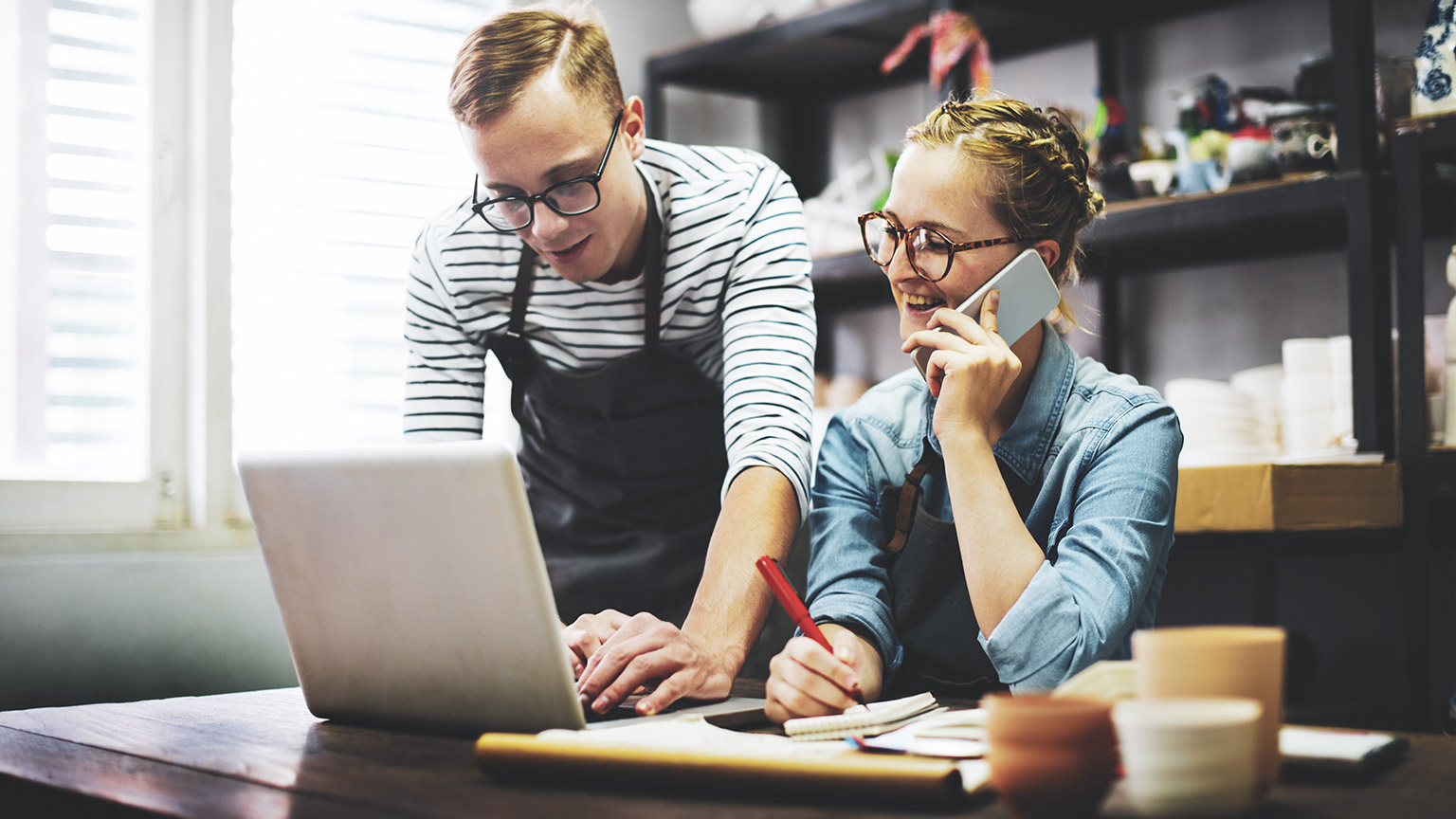 Two business partners entering information into their accounting software