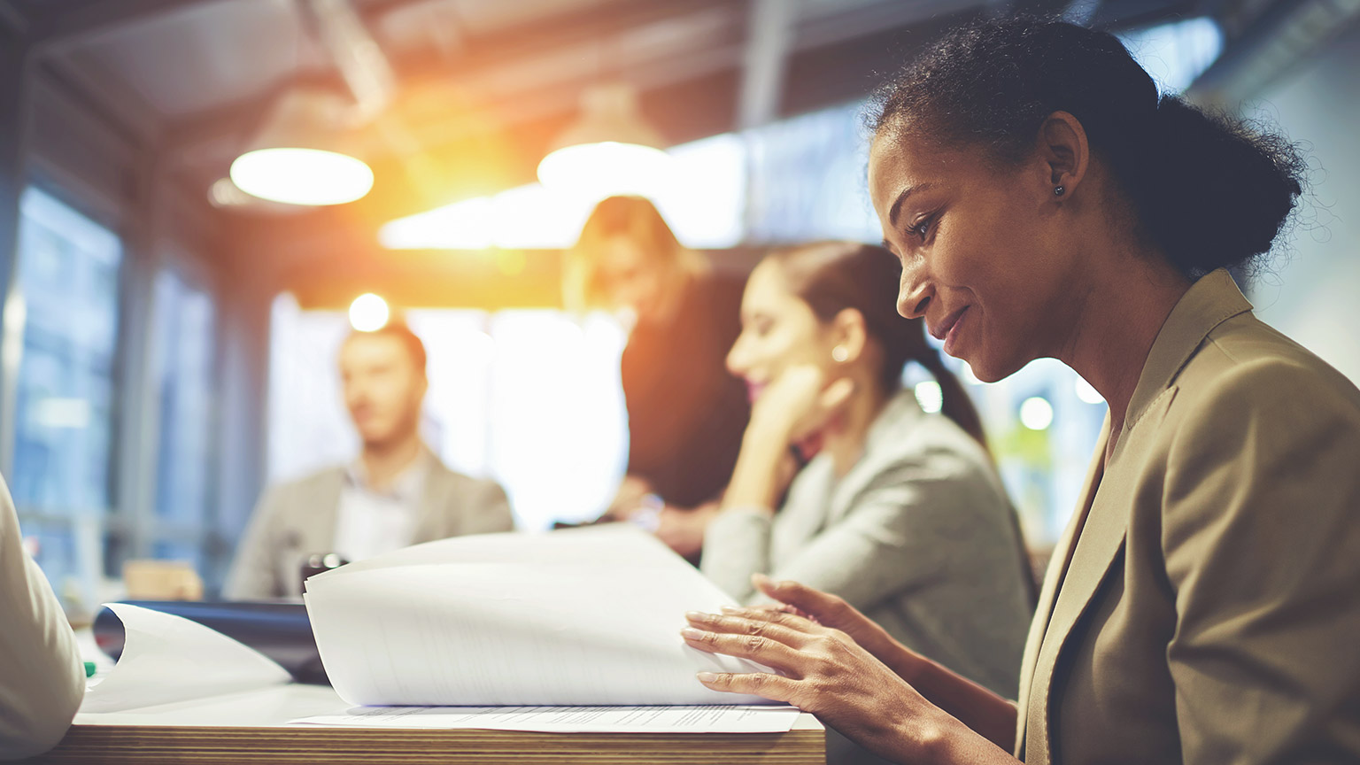 A smiling accountant sitting at a desk reviewing financial information