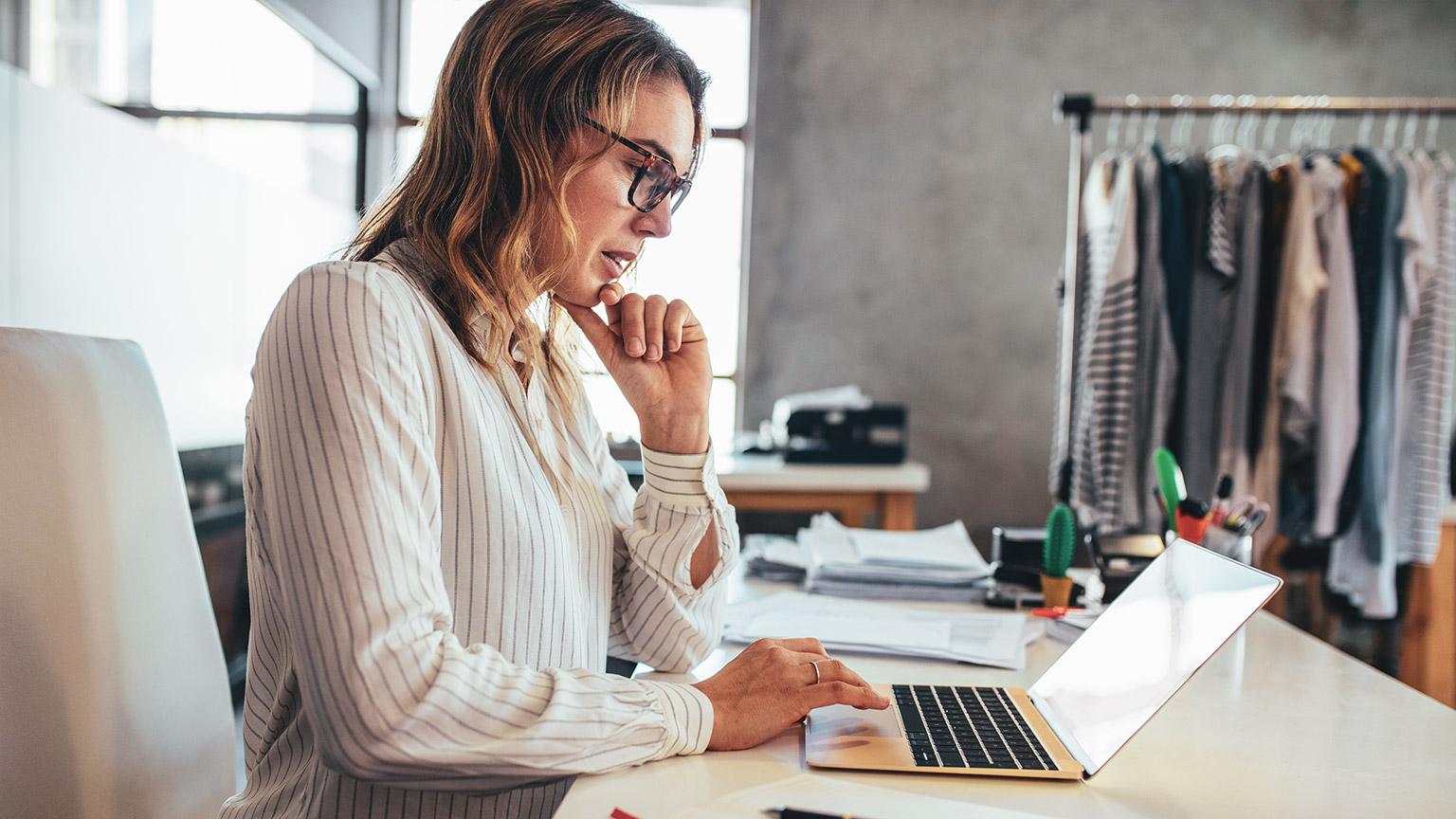 A business owner entering financial data into a laptop