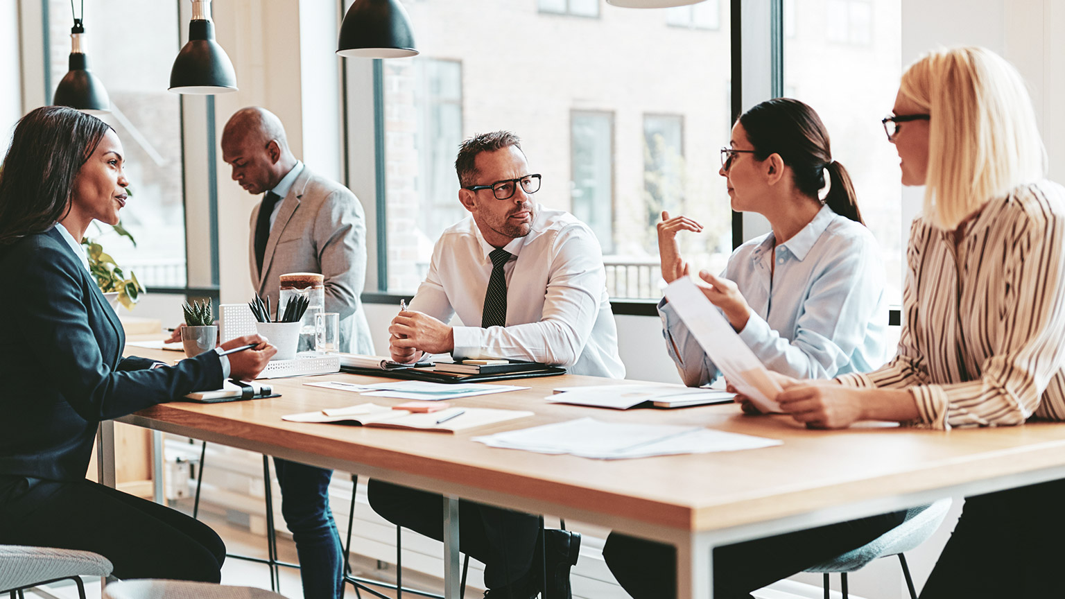 A group of business colleagues discussing work at a large table