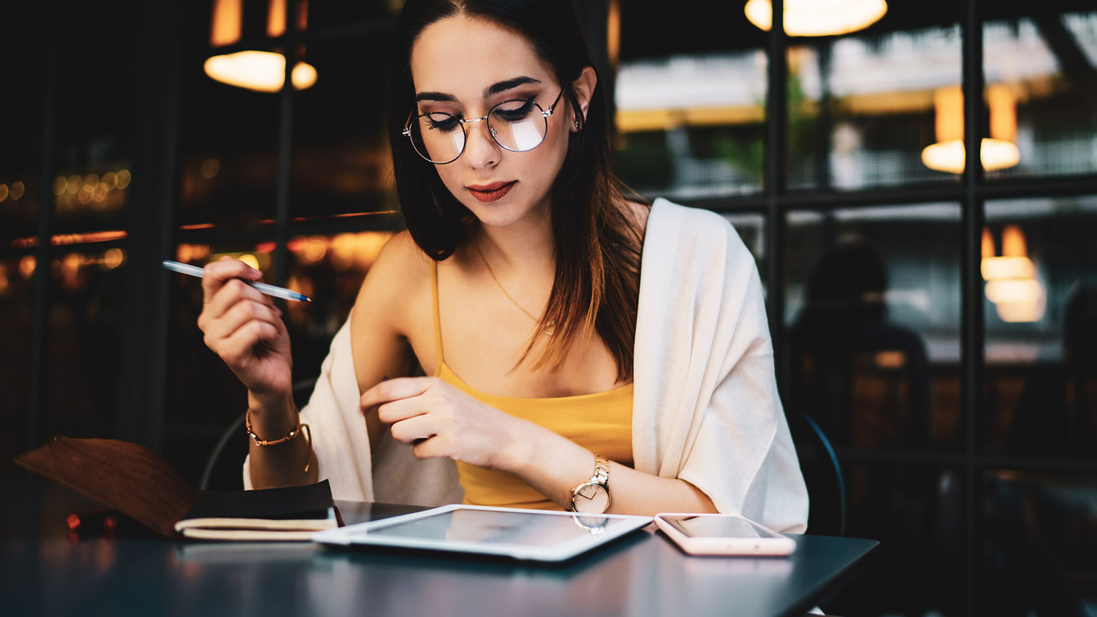 A designer sitting at a desk reading reference materials in a casual environment 