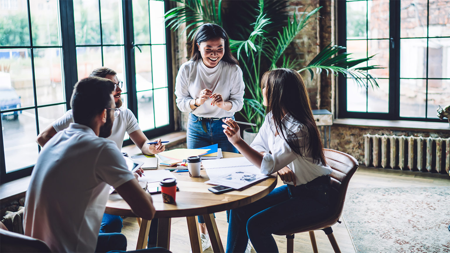 Colleagues seated around a table, brain-storming and communicating their ideas