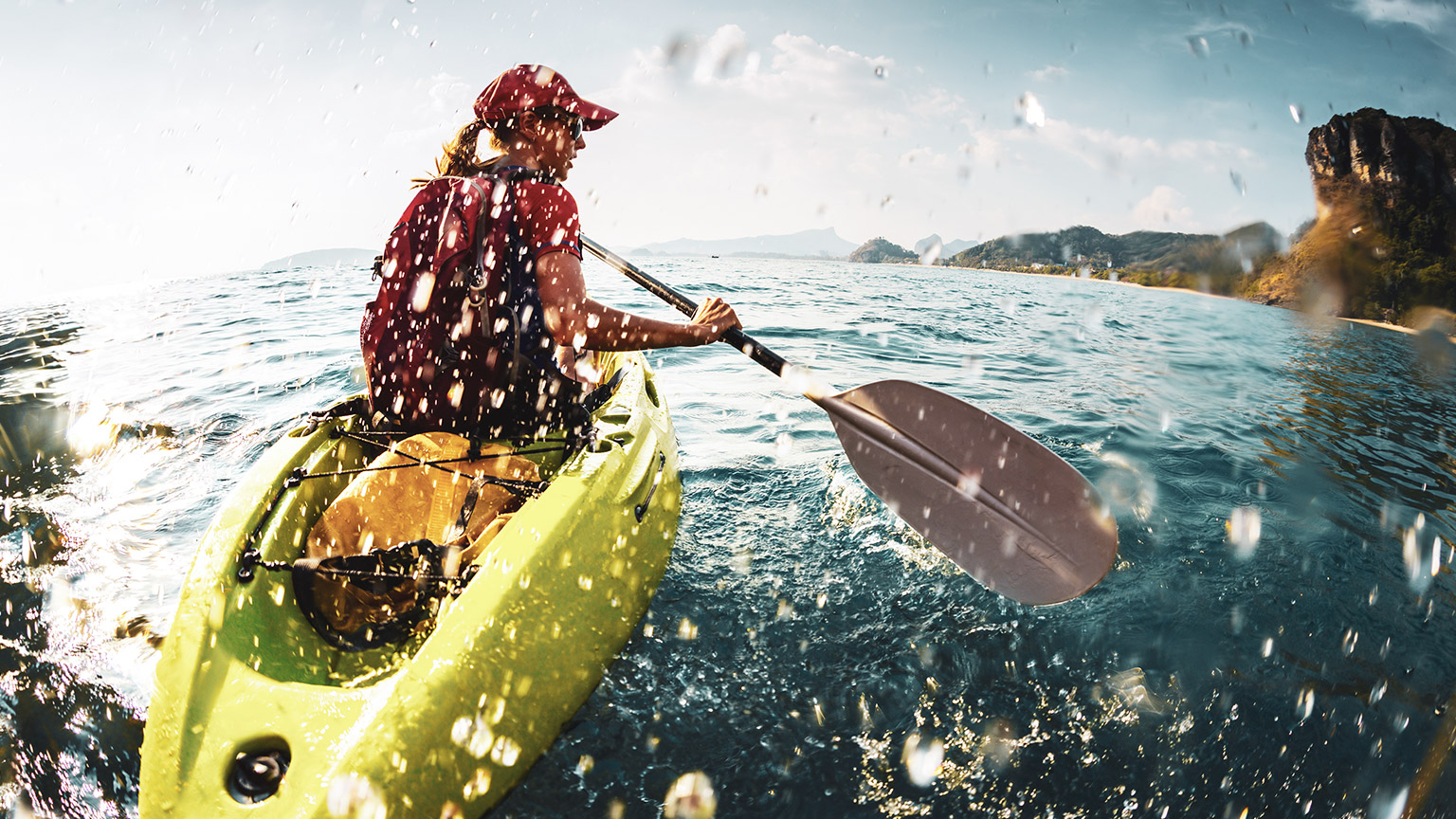 A kayaker paddling in a scenic oceanic setting