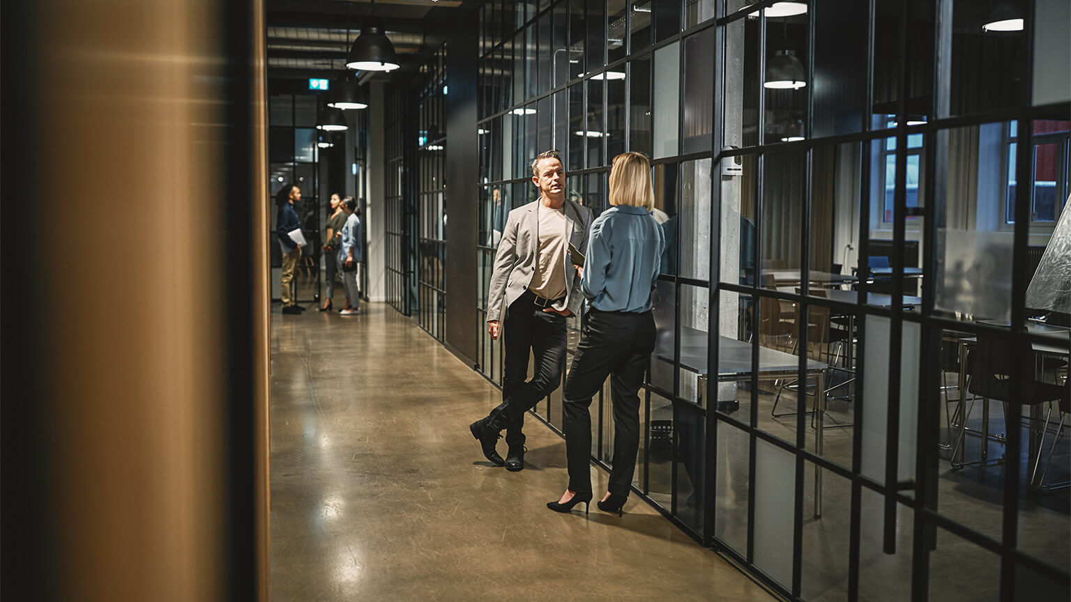 Two colleagues having a difficult conversation in the hallway, prior to joining a meeting