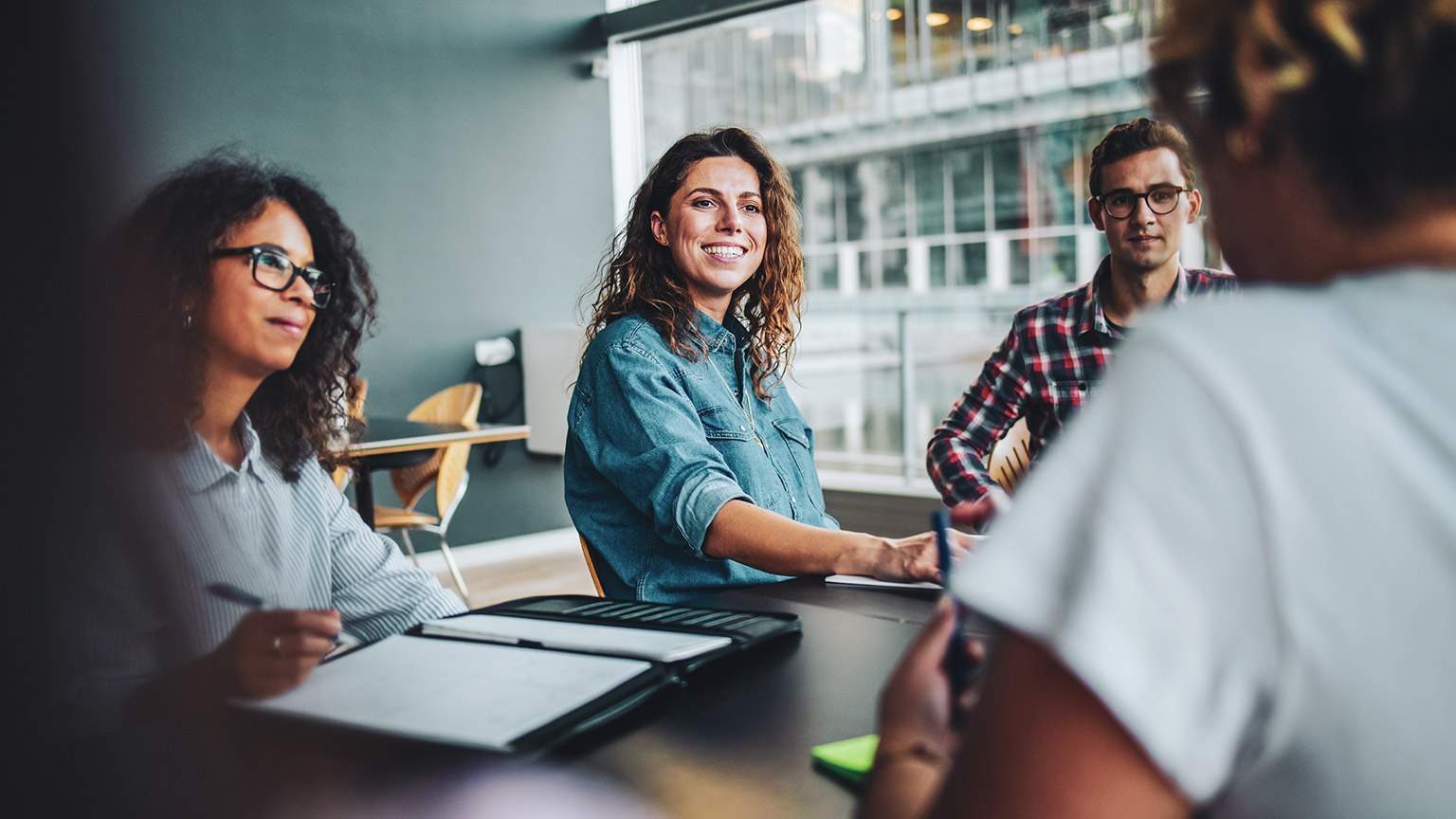 A group of business coworkers discussing a project in a meeting room