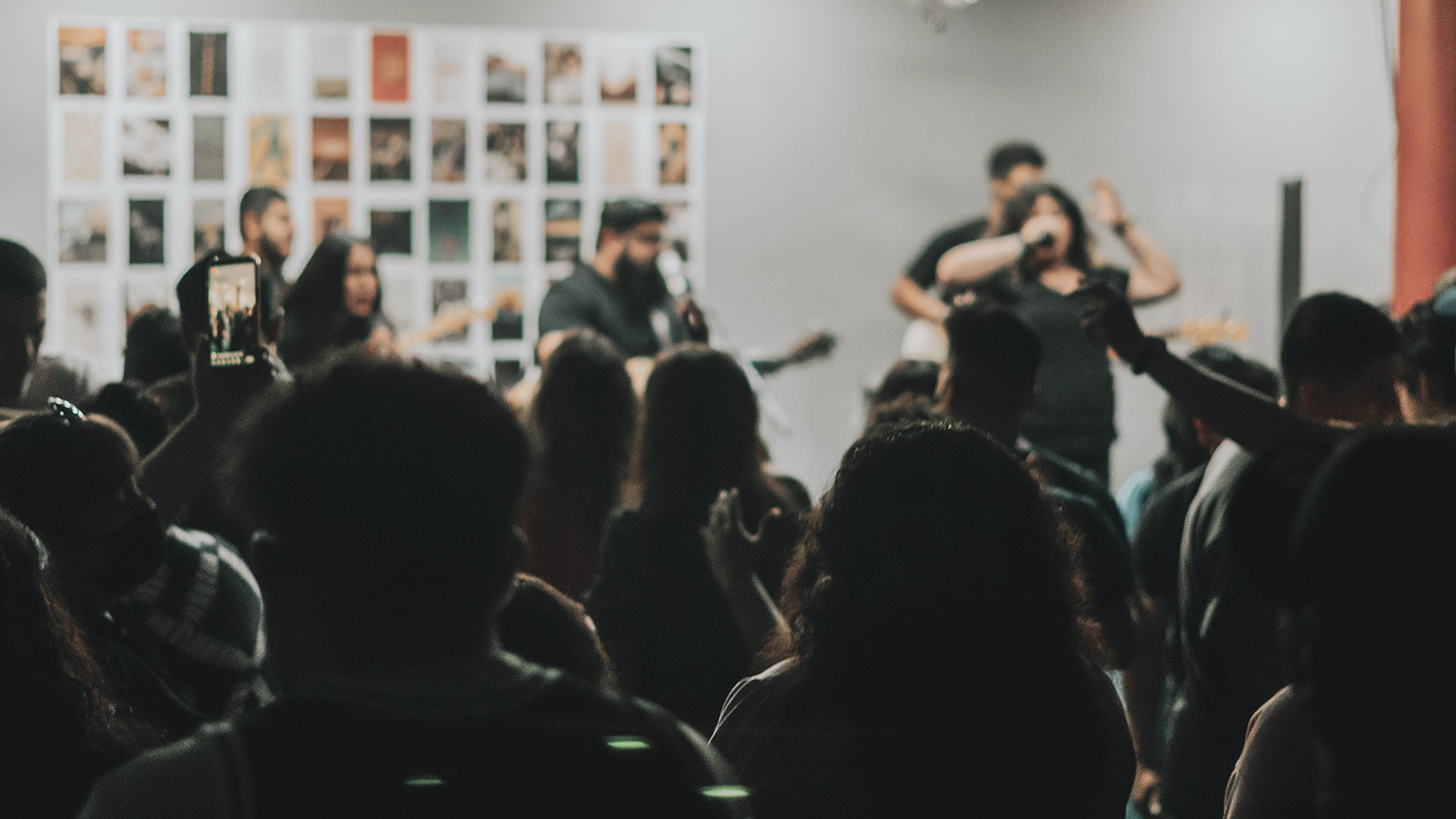 A group of youths enjoying a concert in an intimate indoor venue