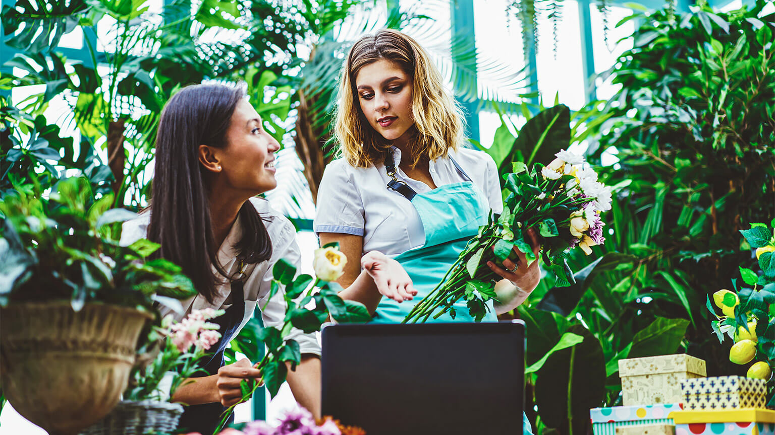 Two colleagues in a florist, discussing the products and services they provide