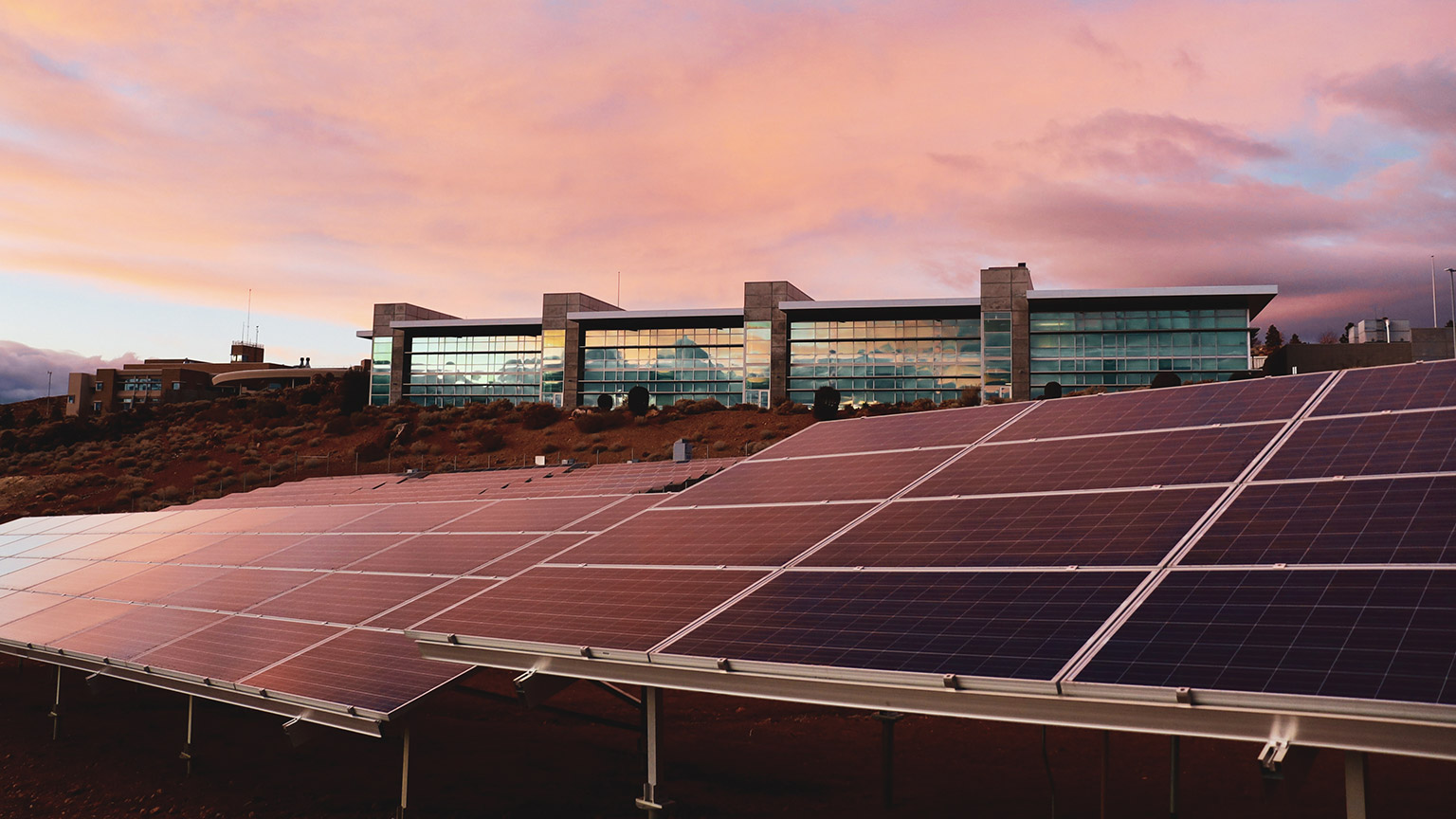 A large office complex with an array of solar panels in front of it