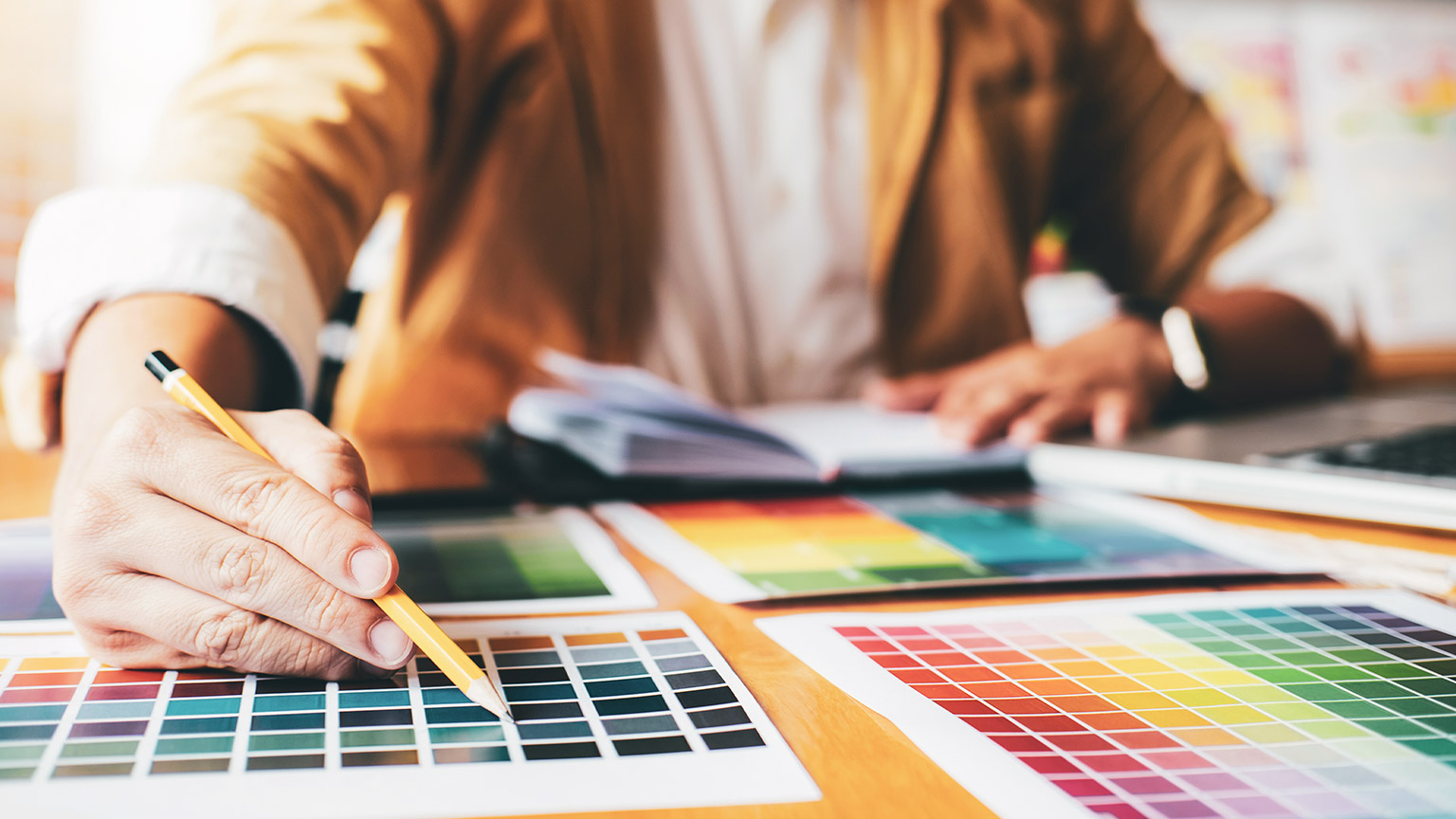 A close view of a designer looking at sheets of colour squares