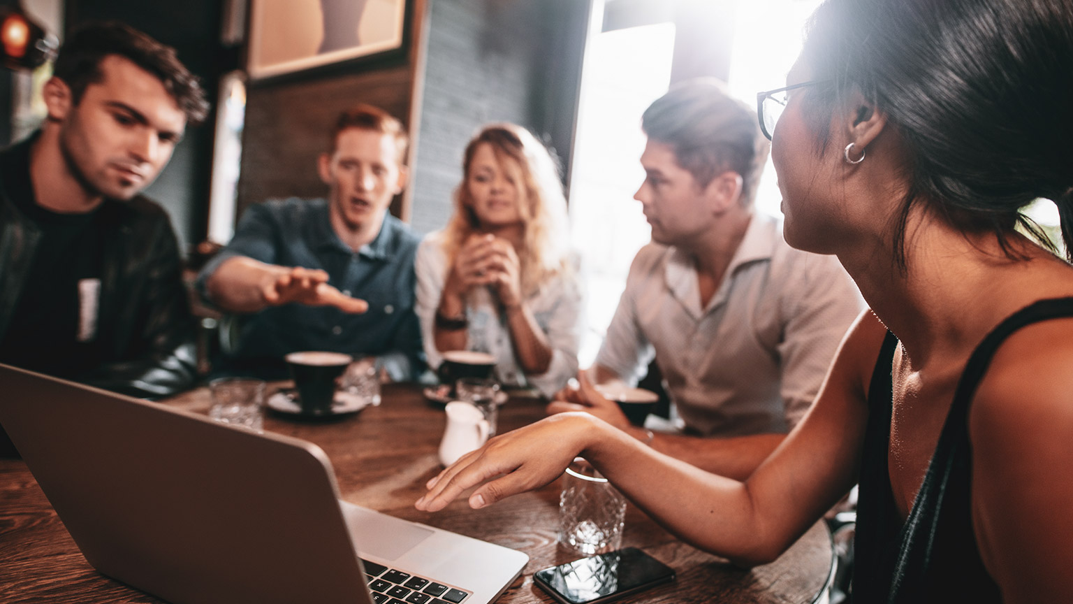 A group of youth workers sitting around a table discussing a project