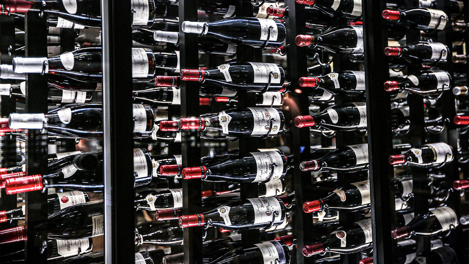 Wine bottles in an illuminated, climate-controlled display case in a retail store