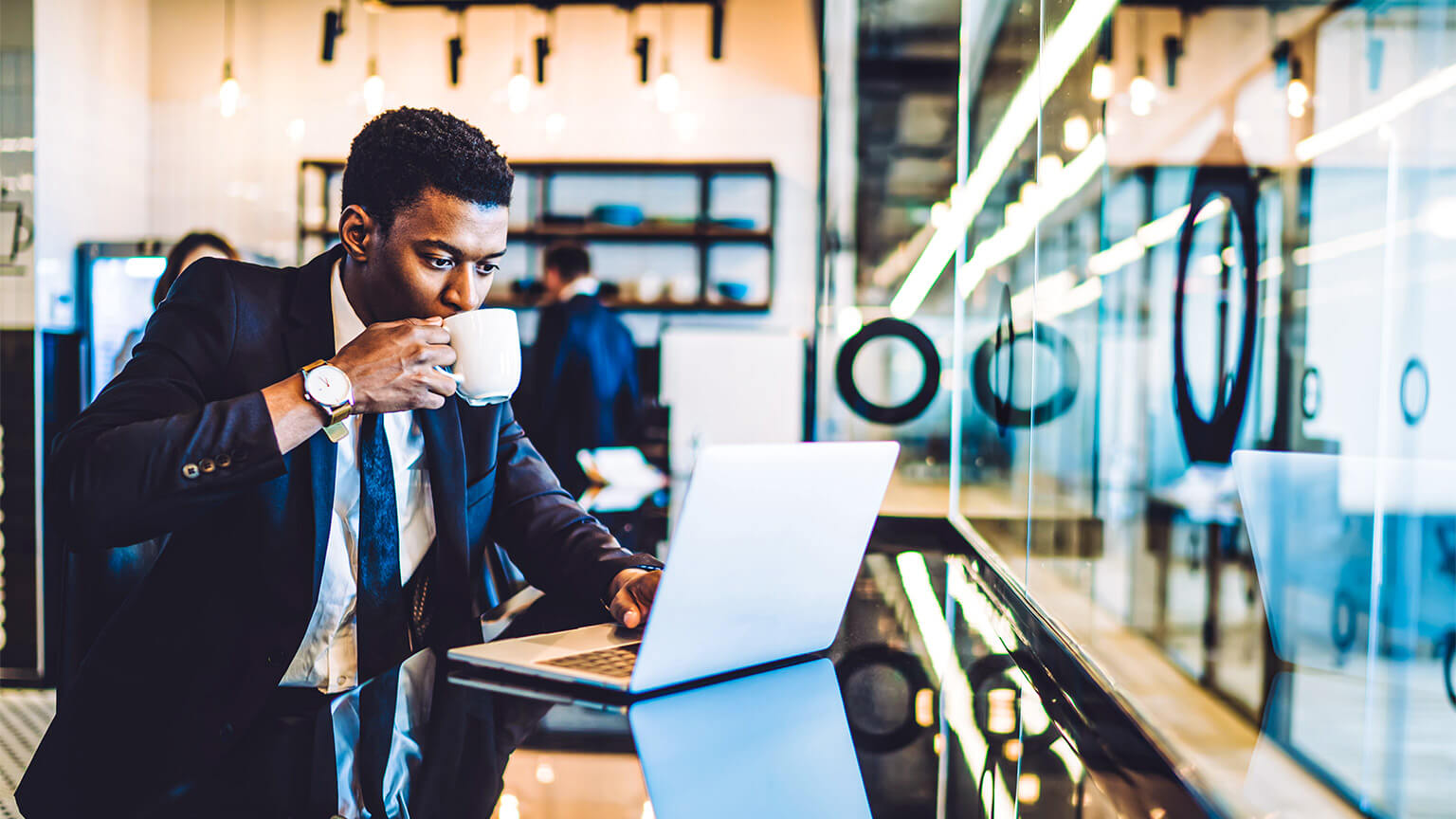 A young executive enjoying a coffee from the cafe embedded in their co-working space