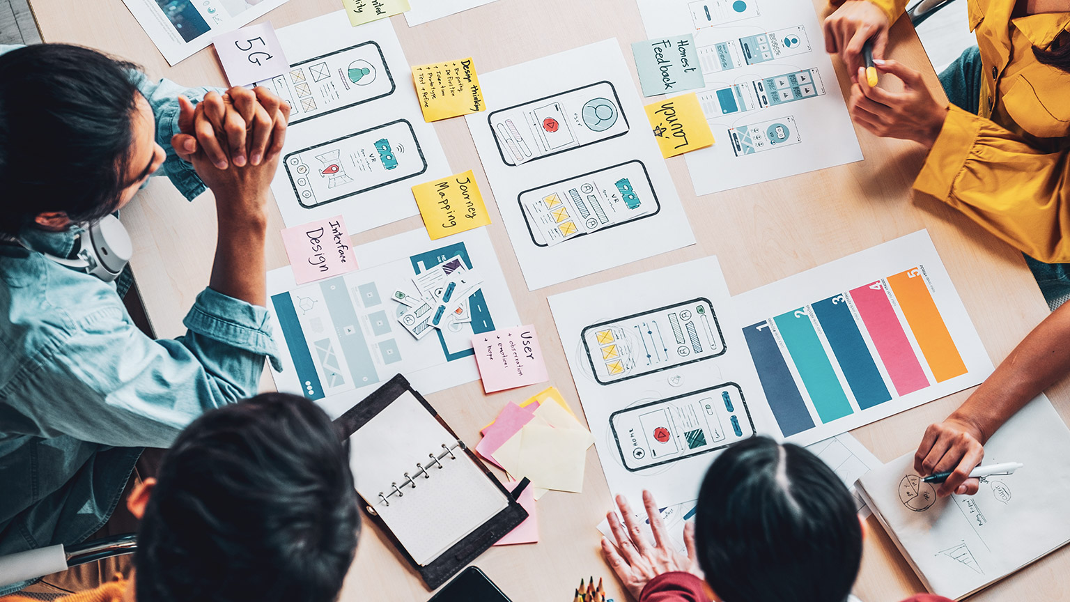 A group of UX designers sitting around a table working on a project