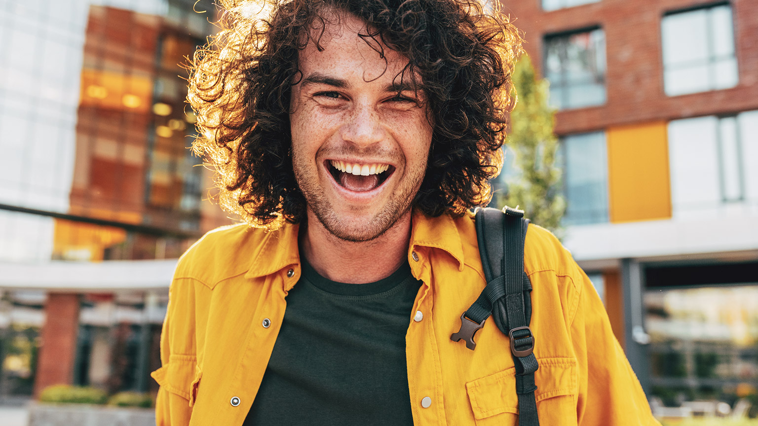 A happy youth worker smiling at the camera in an outdoor environment