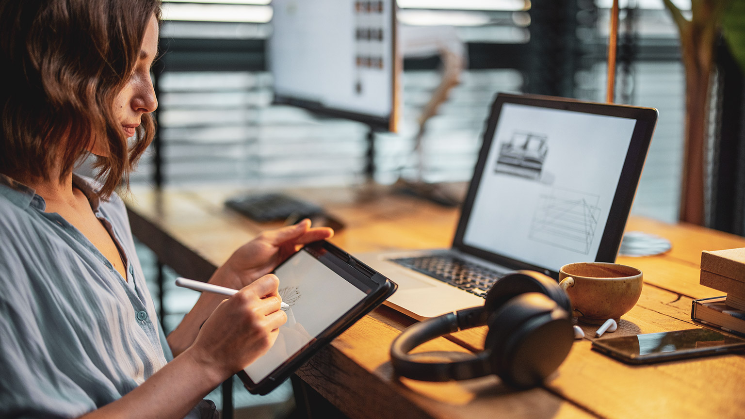 A designer working on an illustration with a stylus and drawing tablet