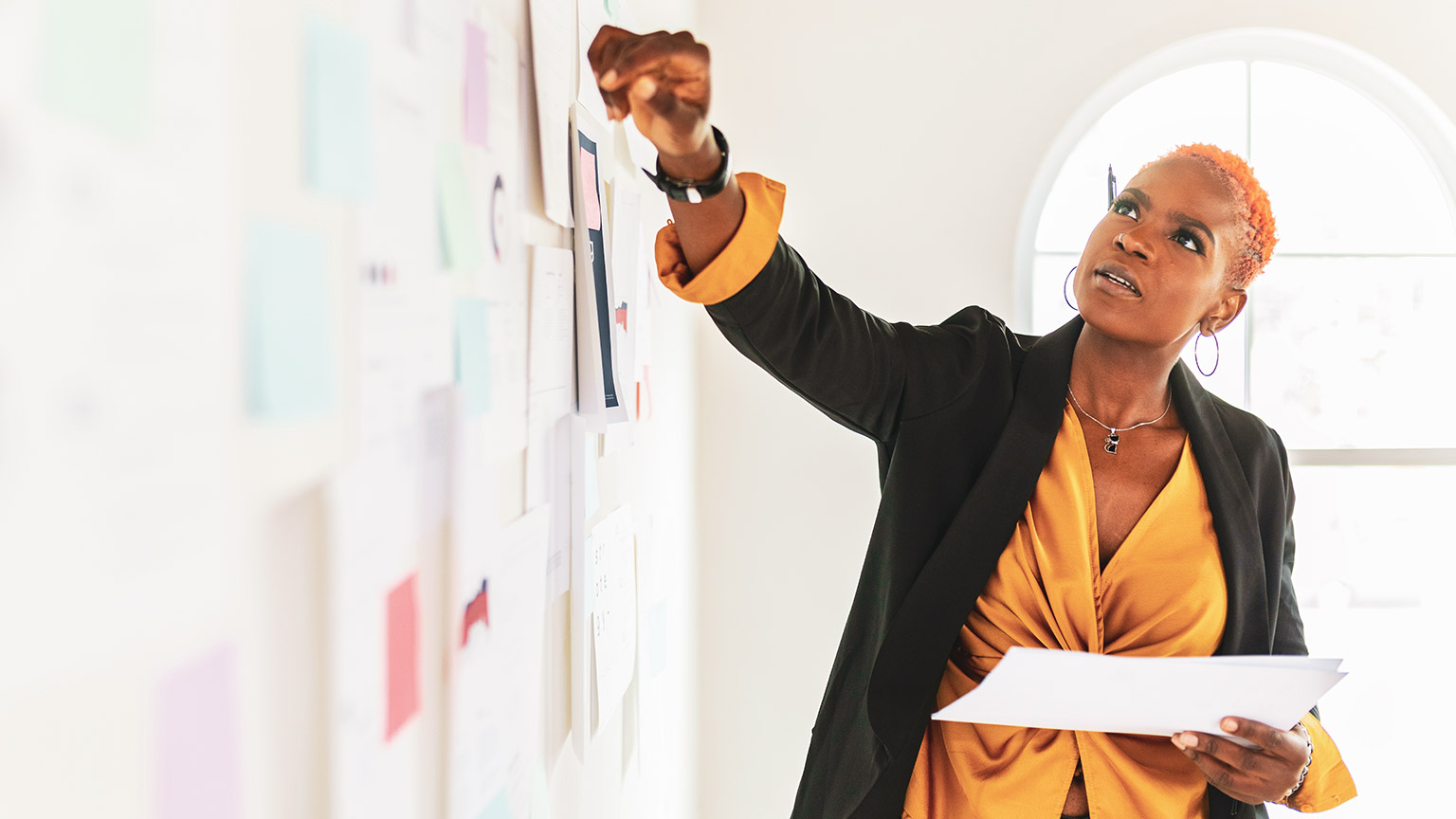 A designer working on a user journey on a wall