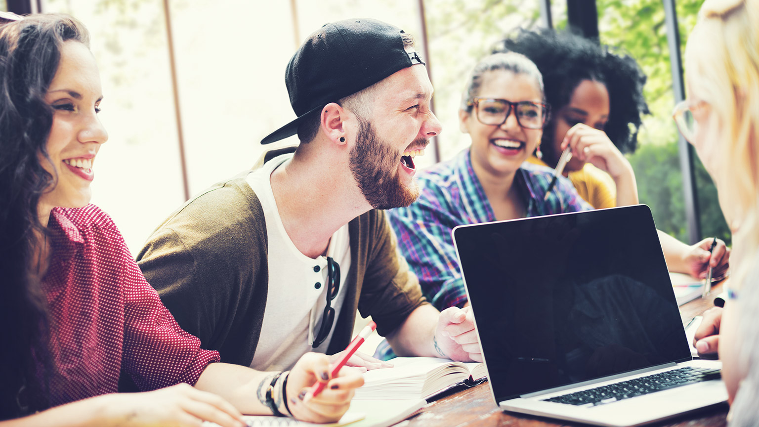 A group of youth workers holding a meeting on a table in a casual office environment