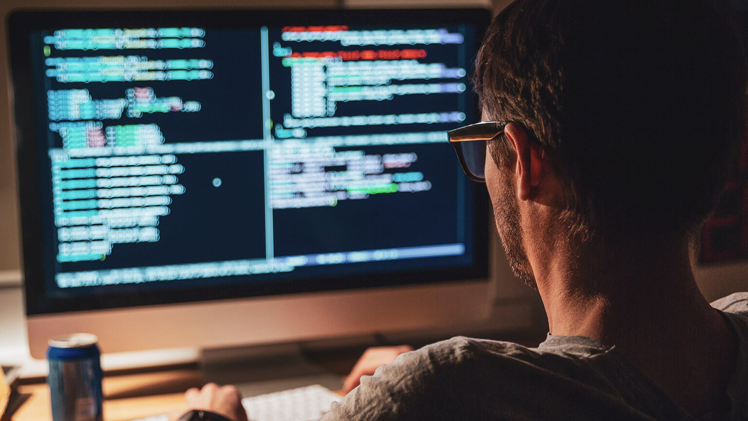 Over-the-shoulder view of a designer viewing the code of a project he is working on