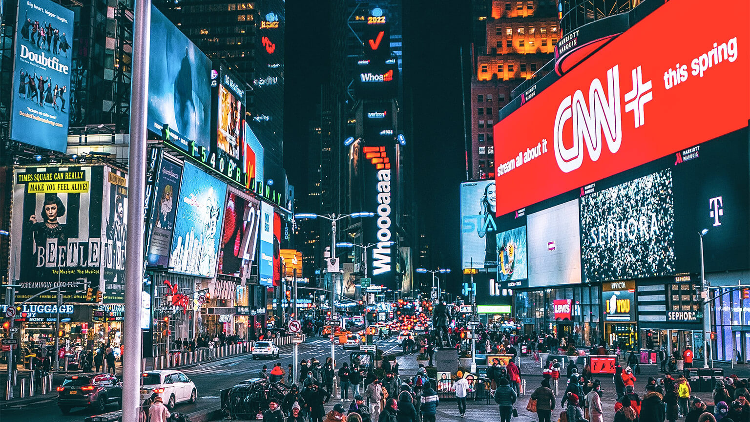 A busy intersection in a major city, with a large range of illuminated advertising