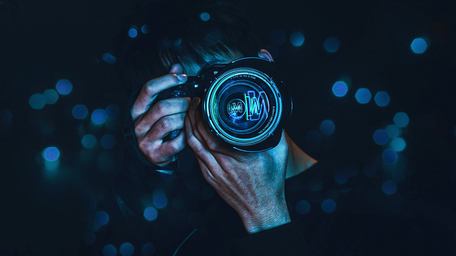 A close view of a photographer at night taking a picture of neon lights