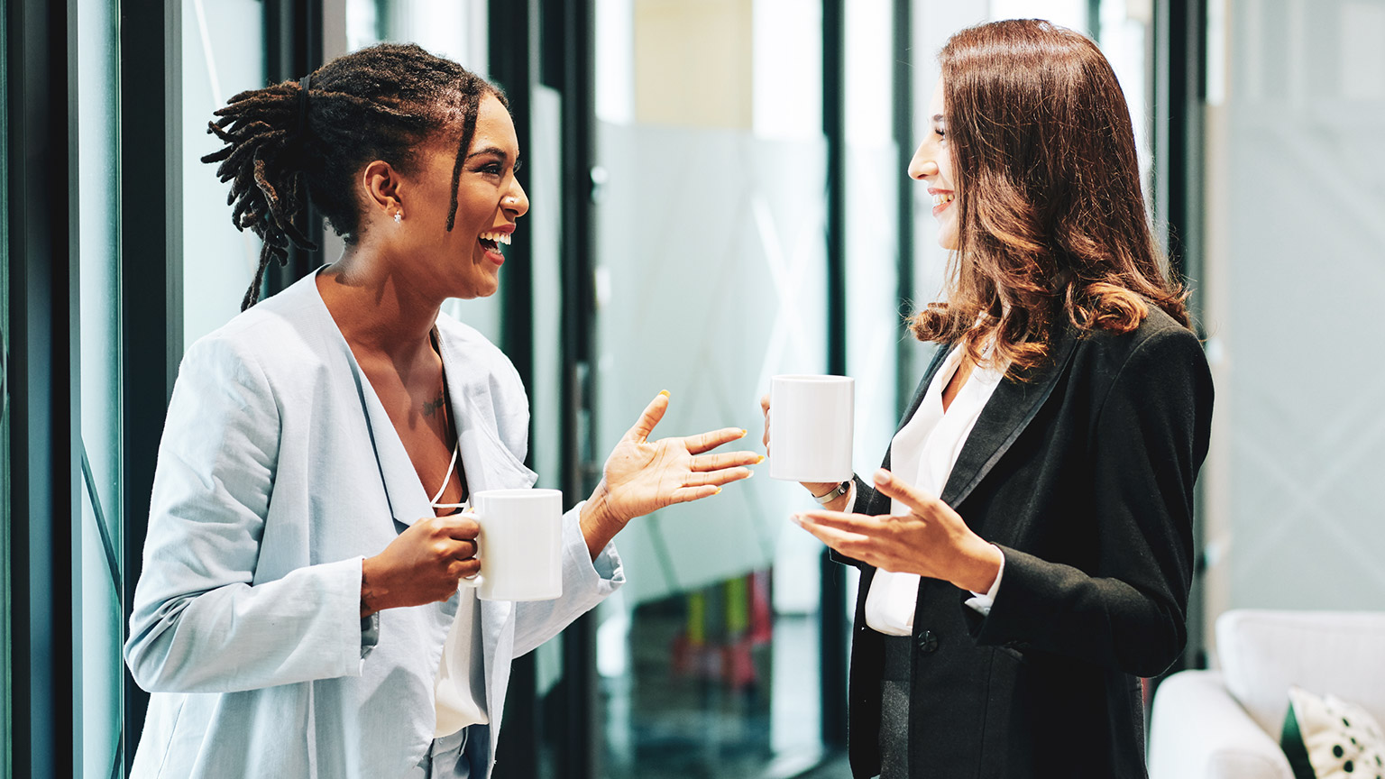 Two colleagues talking about a project in a modern office