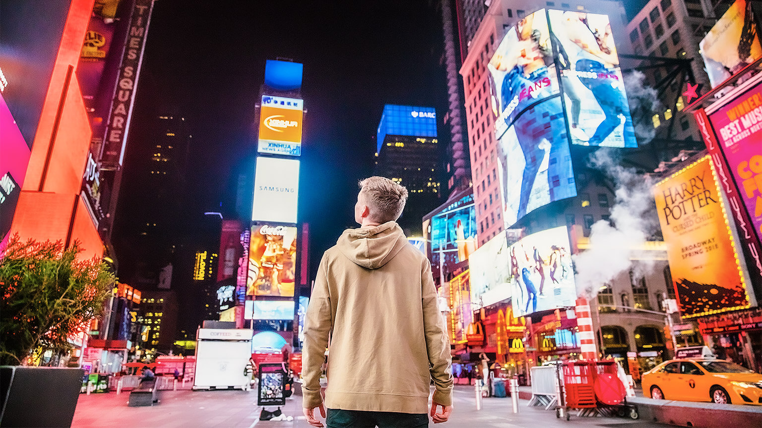 A person looking at all the advertising overhead in a busy metropolis